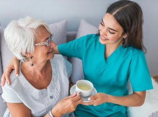 caregiver holding senior womans hands